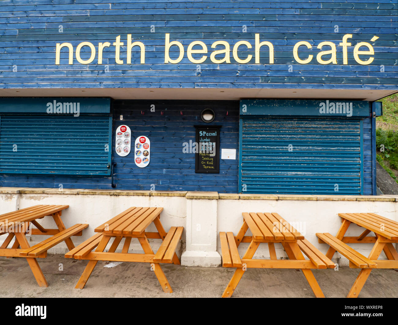 North Beach Cafe in Whitby, Yorkshire mit leeren Picknickbänken im Vordergrund Stockfoto