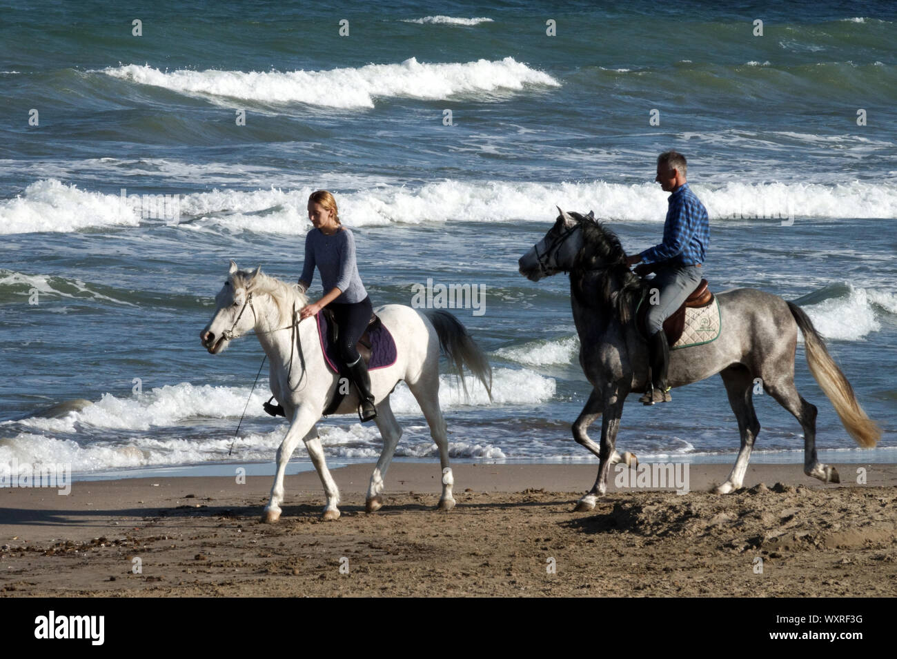 Menschen - Frau Mann, Paar Reiten Pferd auf einem Strand Stockfoto