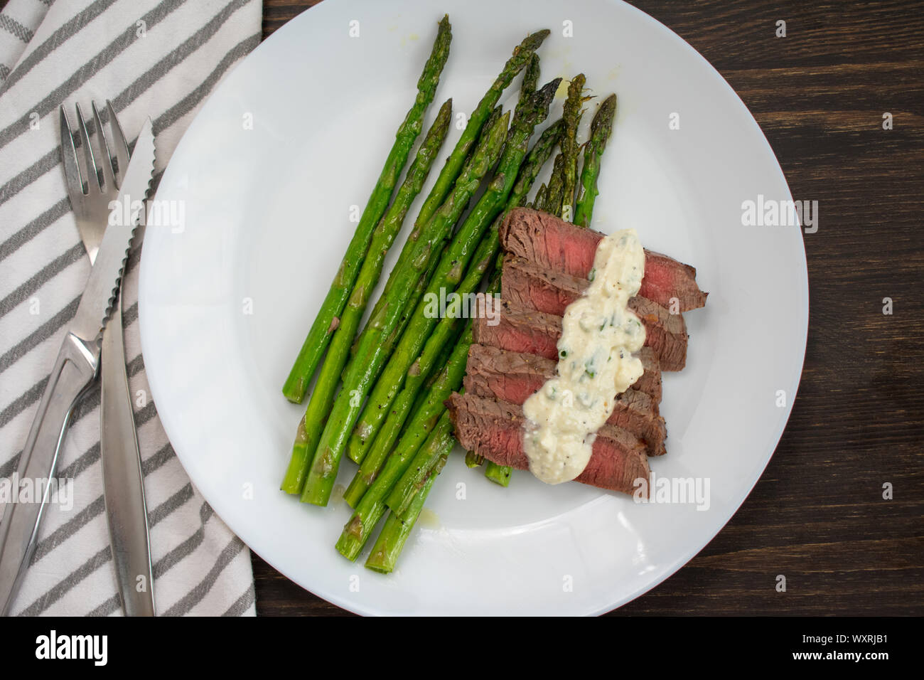 Gebratenes Steak & Spargel mit Feta Sahnesauce: Scheiben von seltenen Sirloin Steak mit Spargel und einer cremigen Feta Käse Sauce. Stockfoto