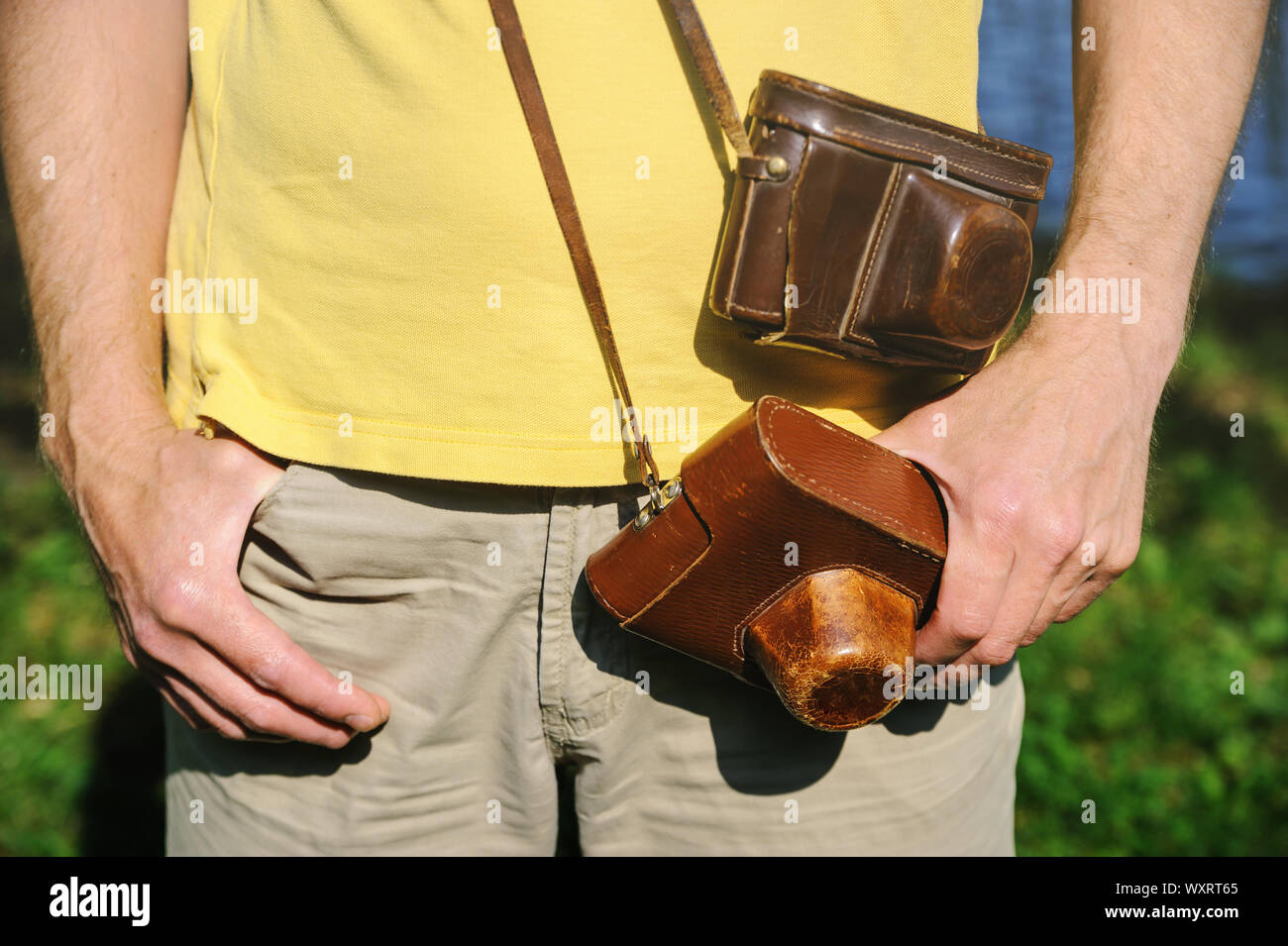 Ein Mann hat zwei vintage Foto Kameras in Leder. Eine Kamera kann eine Hand. Stockfoto