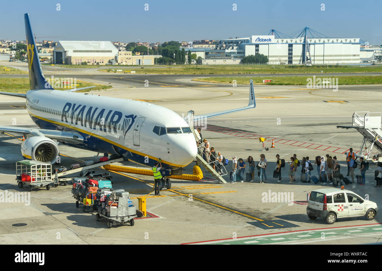 Neapel, Italien - AUGUST 2019: Fluggäste eine Ryanair Boeing 737 Jet am Flughafen Neapel. Das Gepäck wird von Gepäckwagen geladen Stockfoto
