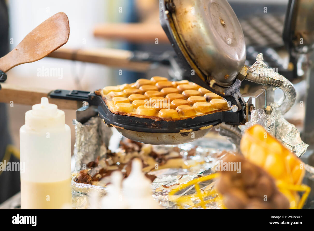 Hamburger fest verpackt in einer Bratpfanne zum Toasten auf einem Tisch im Freien Verpflegung auf einer Veranstaltung oder Street Market Stockfoto
