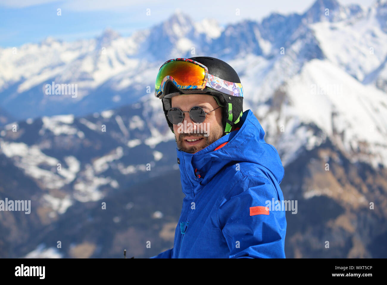 Mann Snowboarder mit blauer Jacke und schwarzem Helm mit Blick auf die Kamera auf dem Mont-Joly-Gipfel von Chamonix/Frankreich. Stockfoto