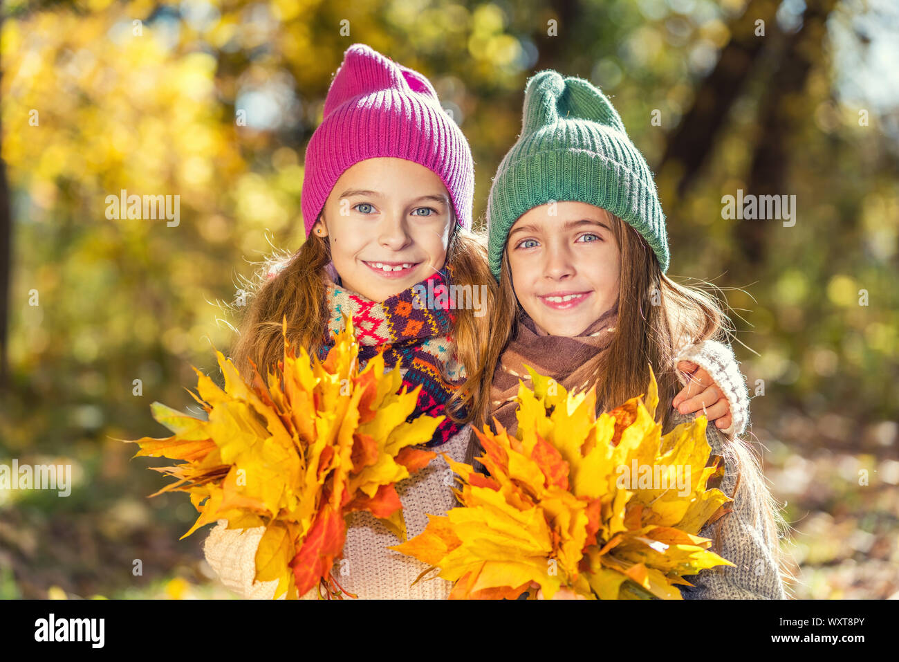 Zwei süße Lächeln 8 Jahre alten Mädchen zusammen Posieren in einem Park auf einem sonnigen Herbsttag. Stockfoto