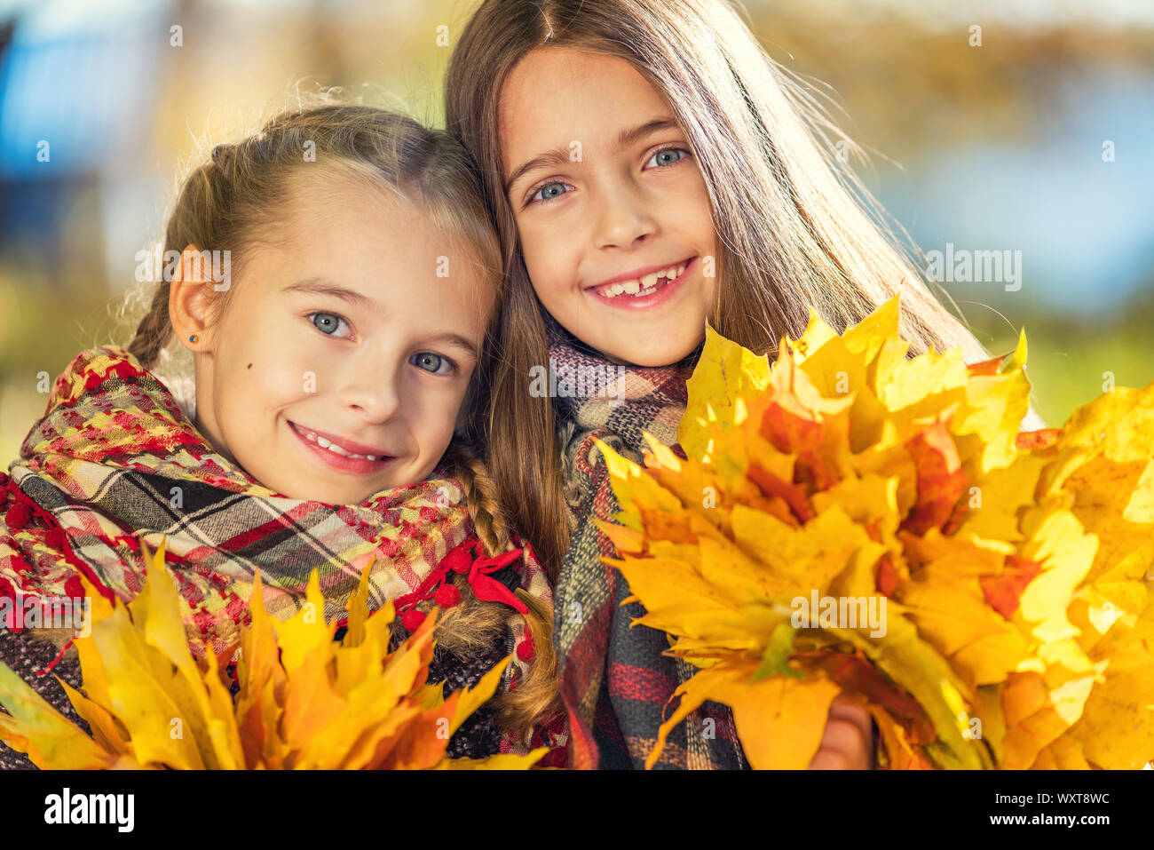 Zwei süße Lächeln 8 Jahre alten Mädchen zusammen Posieren in einem Park auf einem sonnigen Herbsttag. Stockfoto