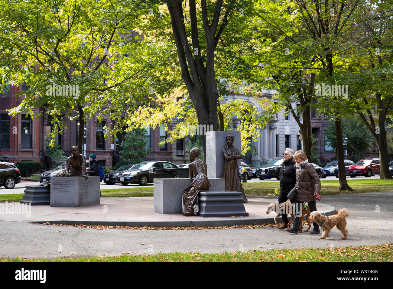 Lokale Leute ihre Hunde von Memorial des Boston Frauen in Commonwealth Avenue Mall in Boston, USA Stockfoto