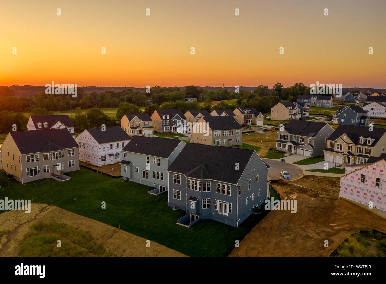 Amerikanische Vorstadtnachbarschaft mit Reihenhäusern und Einfamilienhäusern an der Ostküste der USA mit atemberaubenden Sonnenuntergang Luftaufnahme Stockfoto
