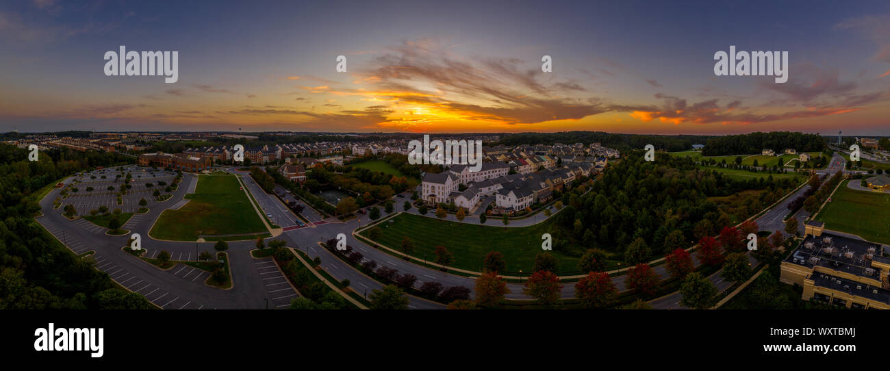 Amerikanische Vorstadtnachbarschaft mit Reihenhäusern und Einfamilienhäusern an der Ostküste der USA mit atemberaubenden Sonnenuntergang Luftaufnahme Stockfoto