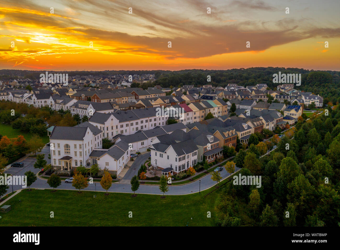 Amerikanische Vorstadtnachbarschaft mit Reihenhäusern und Einfamilienhäusern an der Ostküste der USA mit atemberaubenden Sonnenuntergang Luftaufnahme Stockfoto