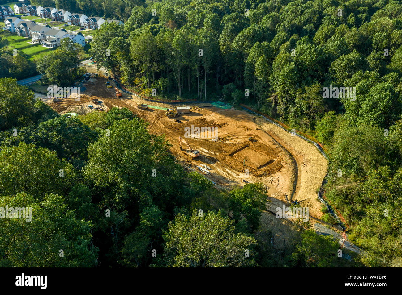 Luftaufnahme von Maryland Baustelle mit Ausrüstung für eine neue Bushaltestelle mit kleinen Gebäuden und einem Schuppen vor Sonnenuntergang Stockfoto
