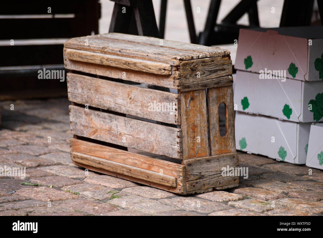 Rustikale alte Holzkiste auf einem gepflasterten Marktplatz Stockfoto