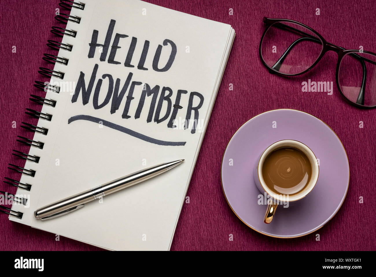 Hallo November - Handschrift in einem Notebook mit einer Tasse Kaffee, Arbeitsbereich business Flach Stockfoto