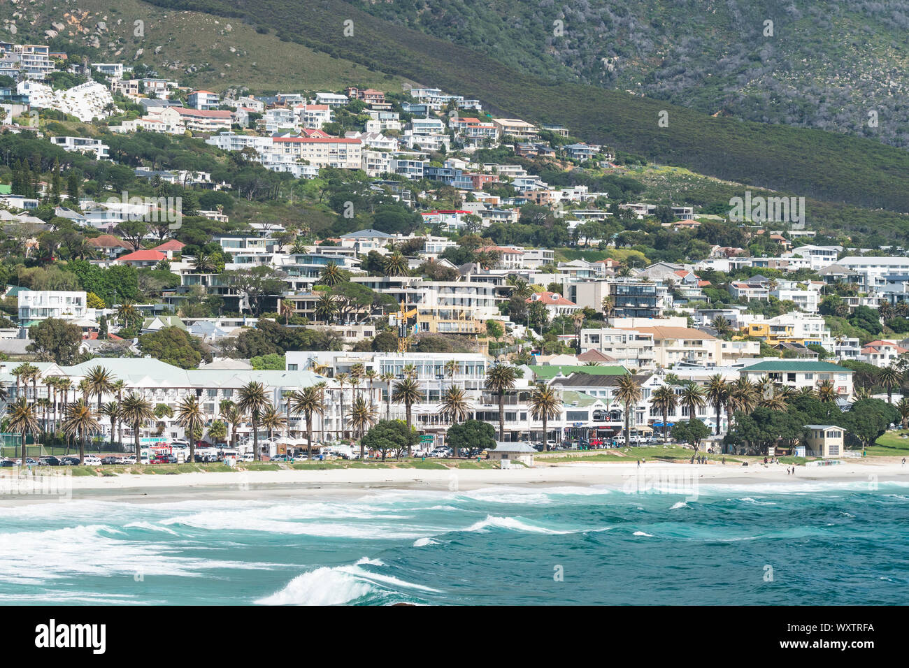 Luxushotels in küstennahen Vorort von Camps Bay, Kapstadt Gebäude und Häuser gegen den Berg mit einem weißen Sandstrand und das türkisblaue Meer Stockfoto