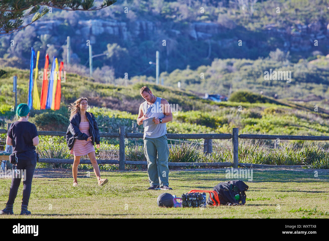 Schauspieler Jake Ryan, Sam Frost und einem Mitglied der Mannschaft zu Film eine Szene von Haus & Weg TV-Serie im Palm Beach, Australien vorbereiten Stockfoto