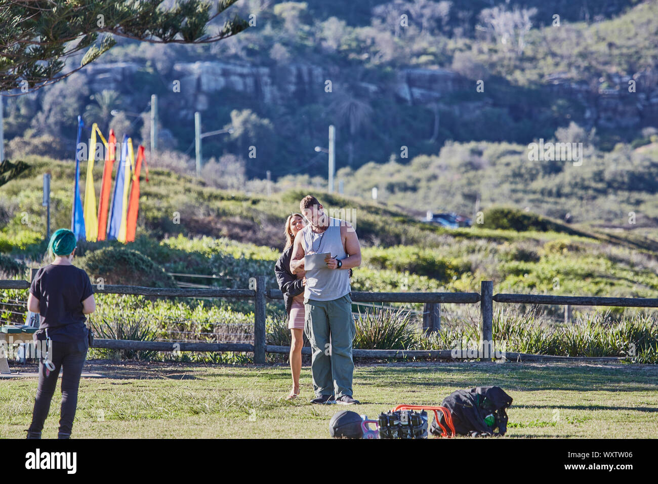 Schauspieler Jake Ryan, Sam Frost und einem Mitglied der Mannschaft zu Film eine Szene von Haus & Weg TV-Serie im Palm Beach, Australien vorbereiten Stockfoto