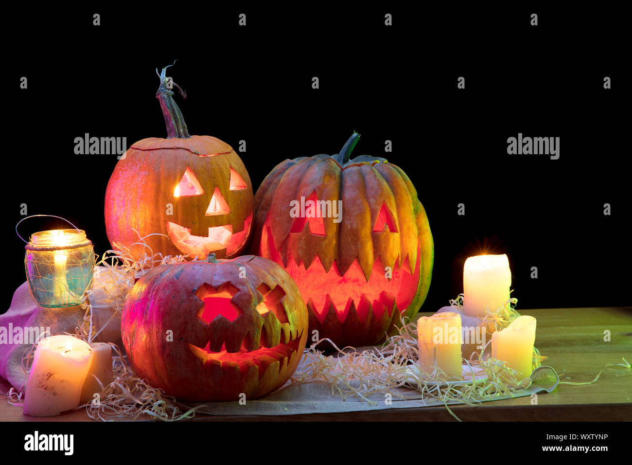 Halloween Pumpkin Head Jack-o-Lantern mit unheimlich böse Gesichter und Kerzen. Saisonale beleuchtete Dekoration. Sieht unheimlich, buntes Neonlicht und dunklen Hintergrund. Urlaub. Schwarzer Freitag, Verkauf. Stockfoto