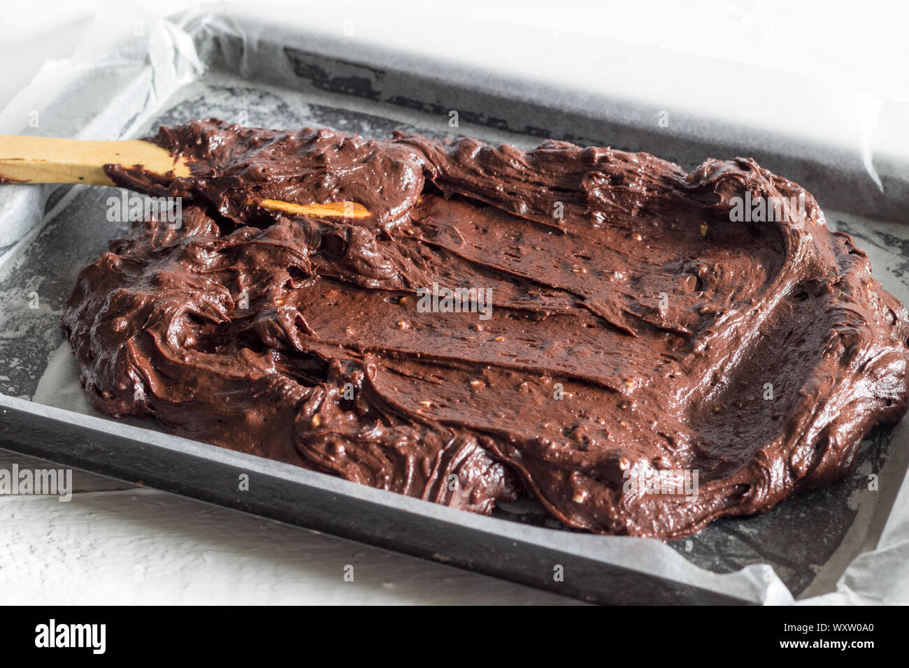 Chocolate Brownie Kuchenteig spooned in Wachs Papier, das Backblech pan-Seite Bild anzeigen Stockfoto