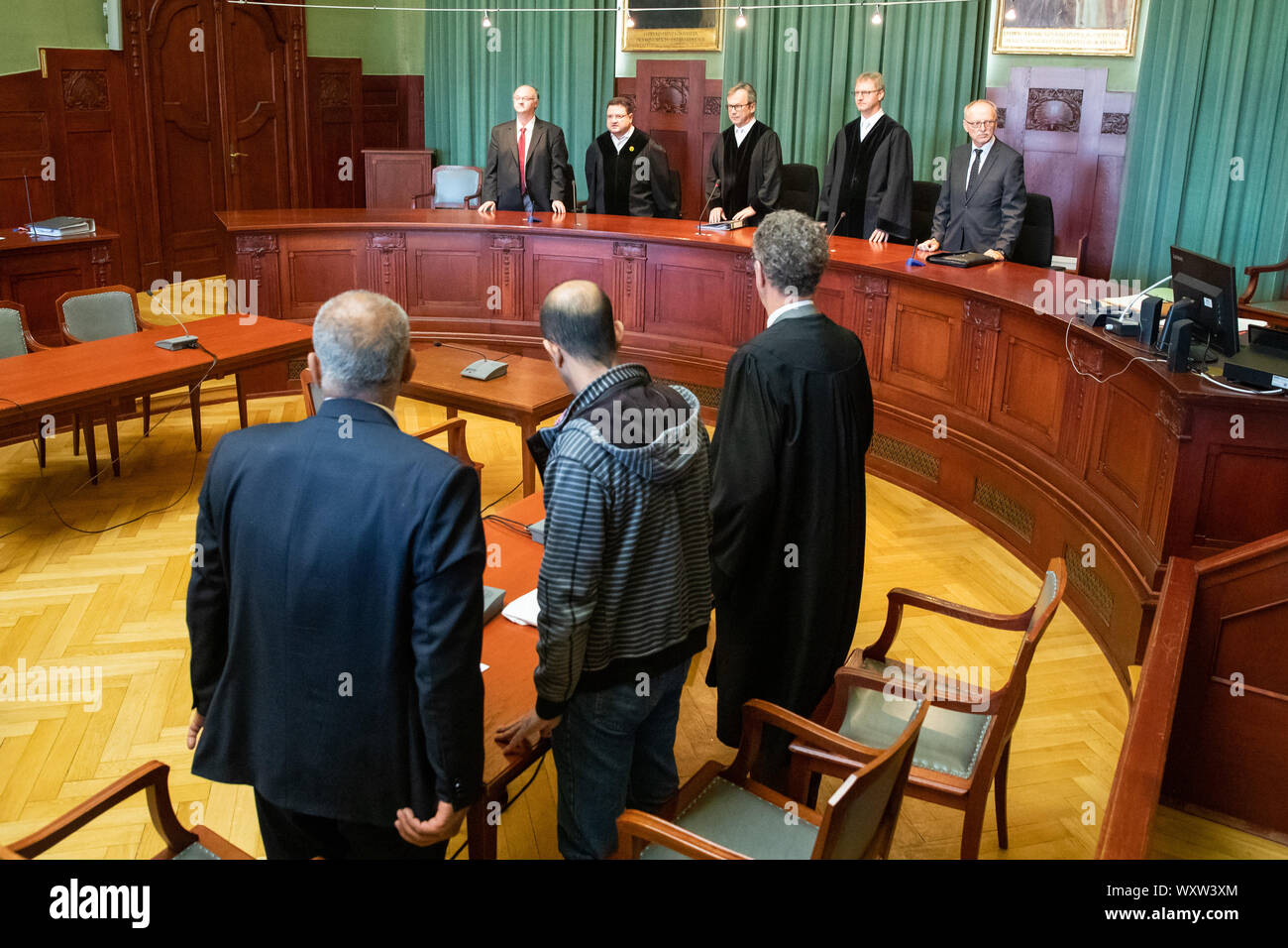 Bayreuth, Deutschland. 18 Sep, 2019. Ein Marokkaner wegen Mordes angeklagt (M vorne) steht zwischen seinem Anwalt (r) und einem Übersetzer bei Beginn der Verhandlungen in der Session und der Bayreuther Landgericht. Das Landgericht hat der 42-jaehrige Angeklagte zu lebenslanger Haft wegen Mordes und gefährlicher Körperverletzung von hitchhiker Sophia Lösche verurteilt. Credit: Daniel Karmann/dpa/Alamy leben Nachrichten Stockfoto