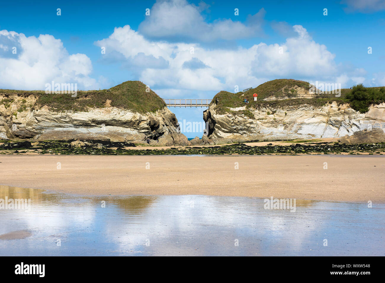Die Fußgängerbrücke verbindet das Festland zu Porth Insel in Newquay in Cornwall. Stockfoto