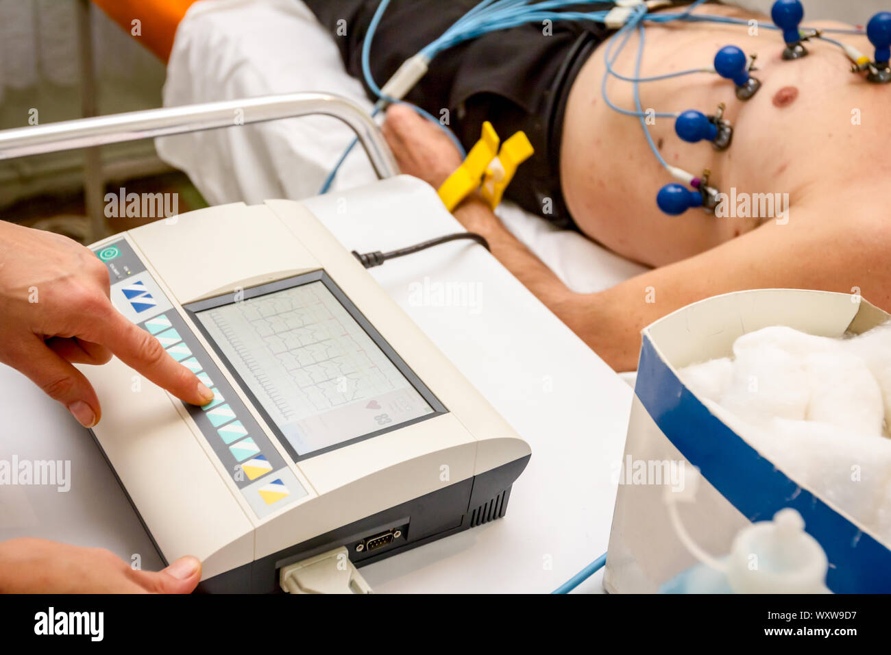 Kardiologe mit EKG-Geräte, Elektrokardiogramm Test des Patienten, der mit Vakuum Sensoren an der Maschine befestigt ist. Stockfoto