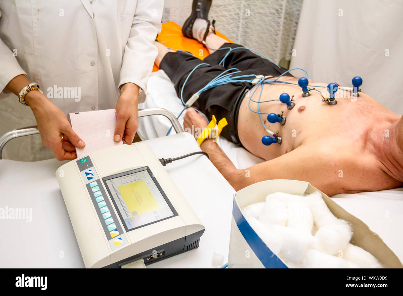 Kardiologe mit EKG-Geräte, Elektrokardiogramm Test des Patienten, der mit Vakuum Sensoren an der Maschine befestigt ist. Stockfoto