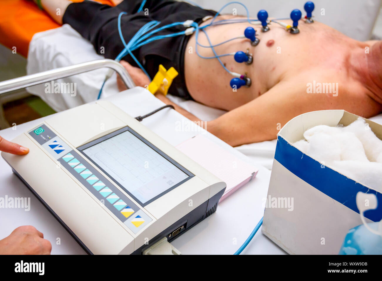 Kardiologe mit EKG-Geräte, Elektrokardiogramm Test des Patienten, der mit Vakuum Sensoren an der Maschine befestigt ist. Stockfoto