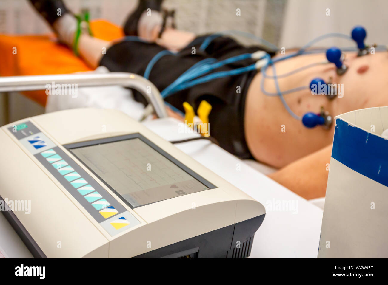 Kardiologe mit EKG-Geräte, Elektrokardiogramm Test des Patienten, der mit Vakuum Sensoren an der Maschine befestigt ist. Stockfoto