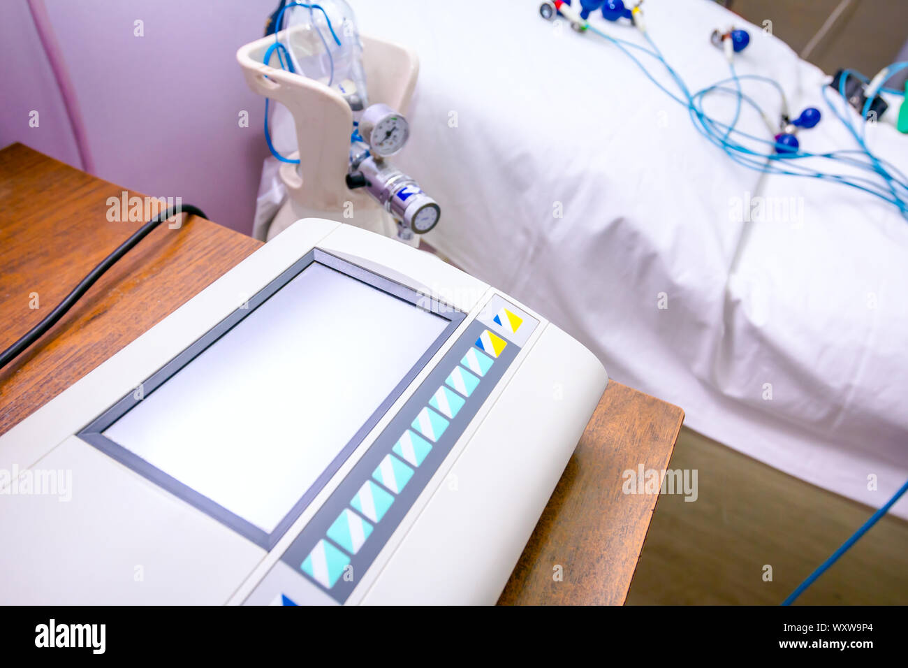 Moderne Maschine mit Display für die Aufzeichnung von EKG- oder EKG über Elektroden, Sensoren für EKG für die Herzschläge des Patienten. Stockfoto