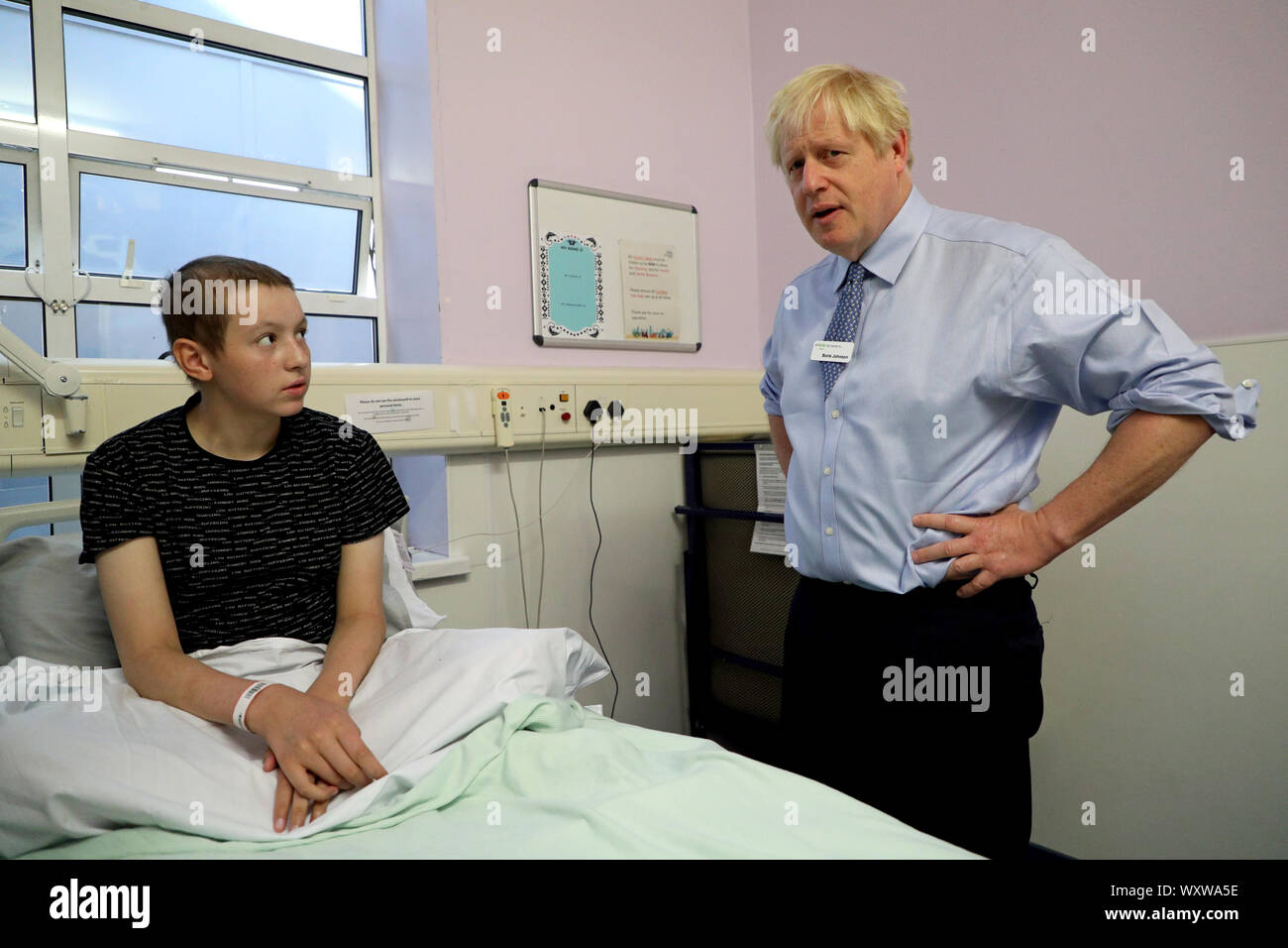 Premierminister Boris Johnson trifft einen jungen Patienten während eines Besuchs in Whipps Cross University Hospital in Leytonstone, East London. Stockfoto