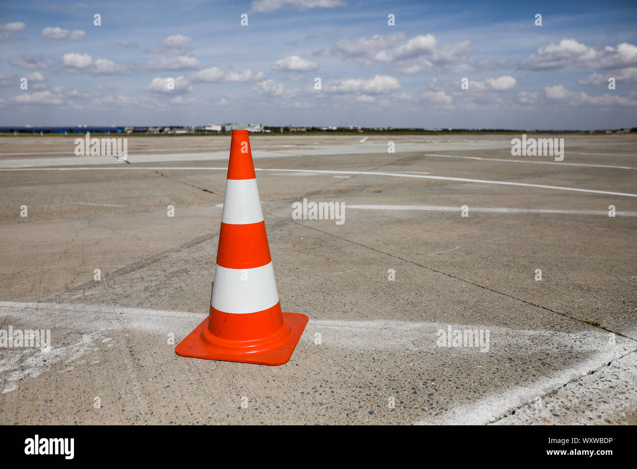 Orange traffic safety cone on an airport runway (taxiway) Stockfoto