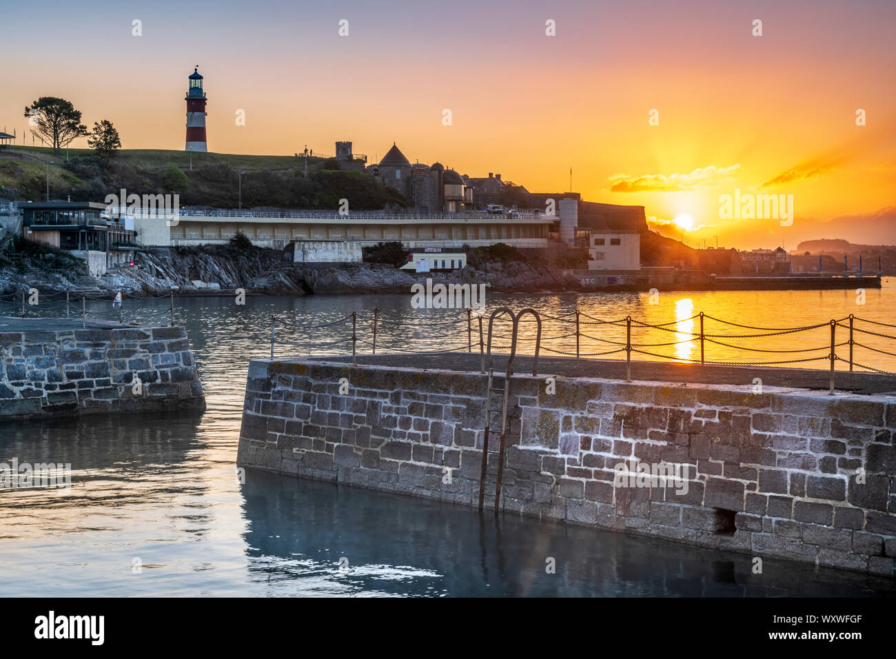 Plymouth, Devon, England. Mittwoch, 18. September 2019. UK Wetter. Nach einer kalten Nacht, die ersten Sonnenstrahlen brechen durch die Wolken, der Himmel leuchtet rosa über smeatons Turm auf der Hacke und den Hafen von Plymouth, Devon, Südwest-England. Credit: Terry Mathews/Alamy leben Nachrichten Stockfoto