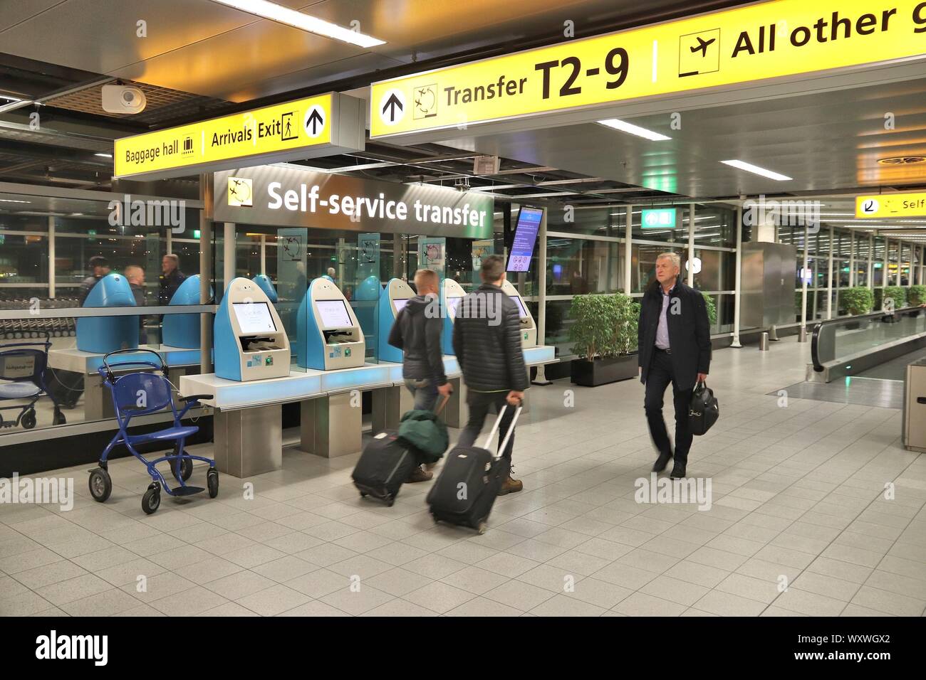 AMSTERDAM, NIEDERLANDE, 21. NOVEMBER 2018: Reisende besuchen Flughafen Schiphol in Amsterdam. Der Flughafen Schiphol ist der 12 verkehrsreichsten Flughafen der Welt mit mehr Stockfoto