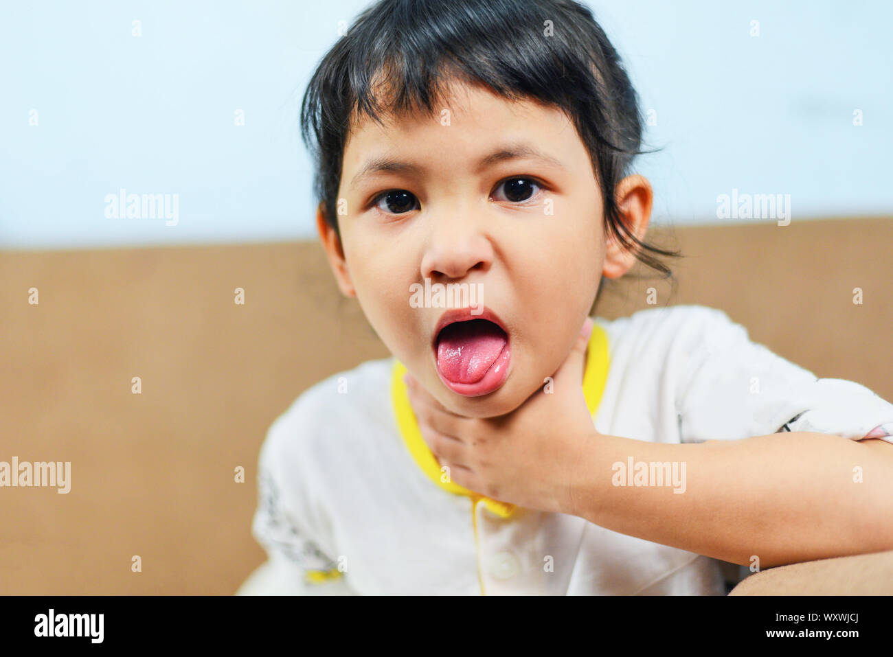 Husten und Halsschmerzen/asiatischen Mädchen krank Fieber Kälte, Kind Zunge rausstrecken Stockfoto