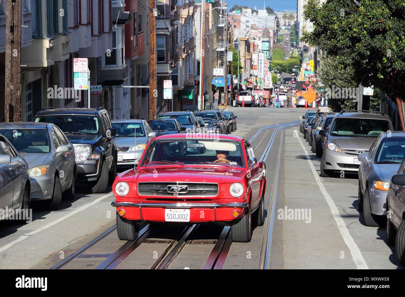 SAN FRANCISCO, USA - April 9, 2014: Frau Antriebe roten Mustang in Chinatown in San Francisco, USA. San Franciscos Chinatown ist der größte chinesische Commun Stockfoto