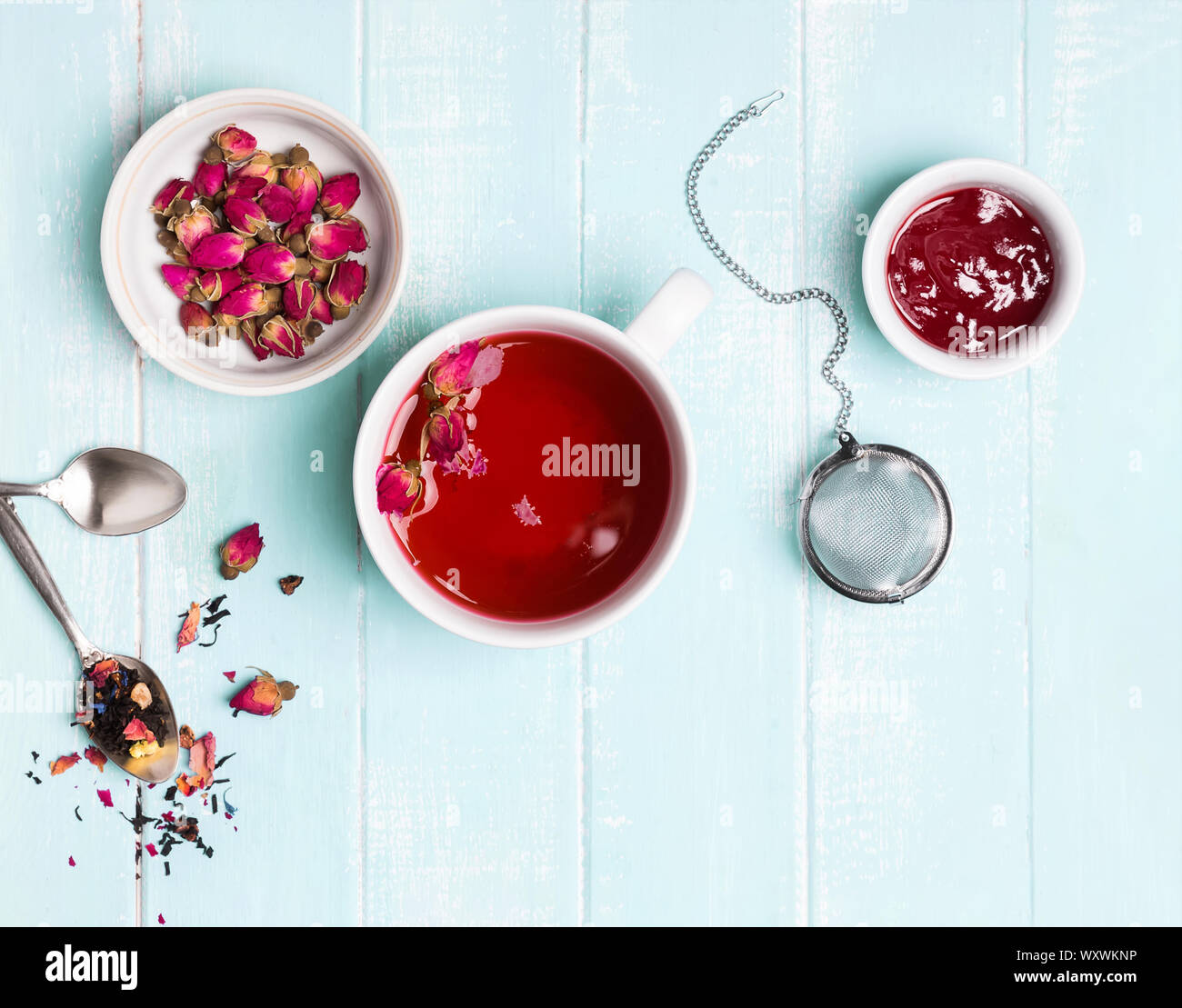 Blumen Tee mit trockenen Rosen auf Pastell mint oder blau Holz- Tabelle, Ansicht von oben. Stockfoto