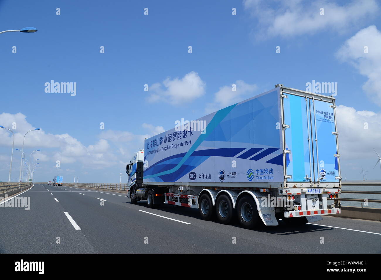 Eine 5-G-Container Lkw von IHDT (Intelligente Heavy-Duty-Truck) von SIPG von SAIC Motor und China Mobile reist auf Donghai Brücke linkin unterstützt. Stockfoto