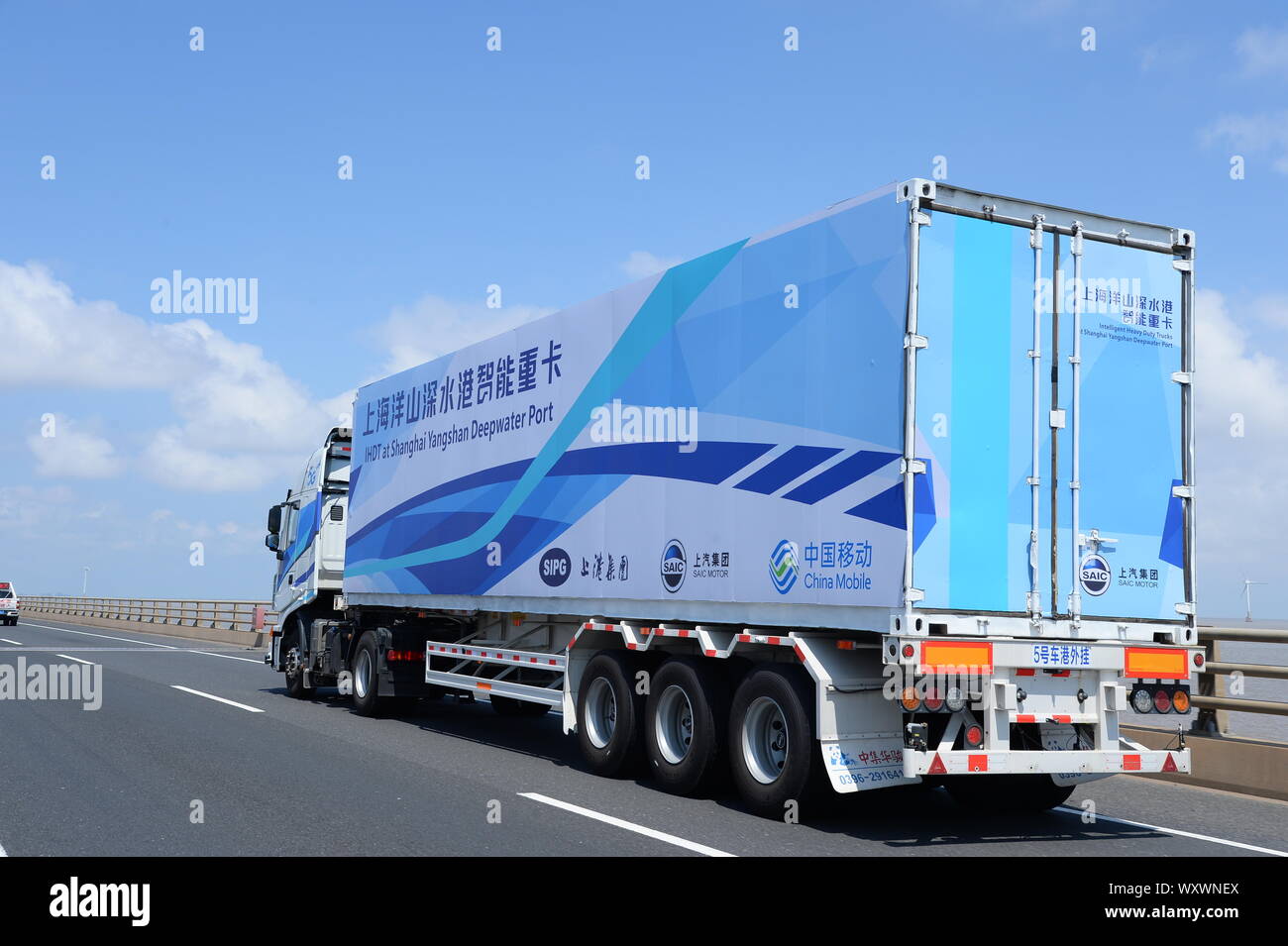 Eine 5-G-Container Lkw von IHDT (Intelligente Heavy-Duty-Truck) von SIPG von SAIC Motor und China Mobile reist auf Donghai Brücke linkin unterstützt. Stockfoto