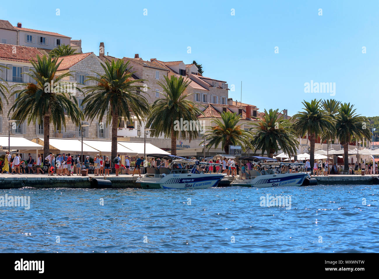 Touristen zu Fuß entlang der Uferpromenade in Hvar, Kroatien Stockfoto