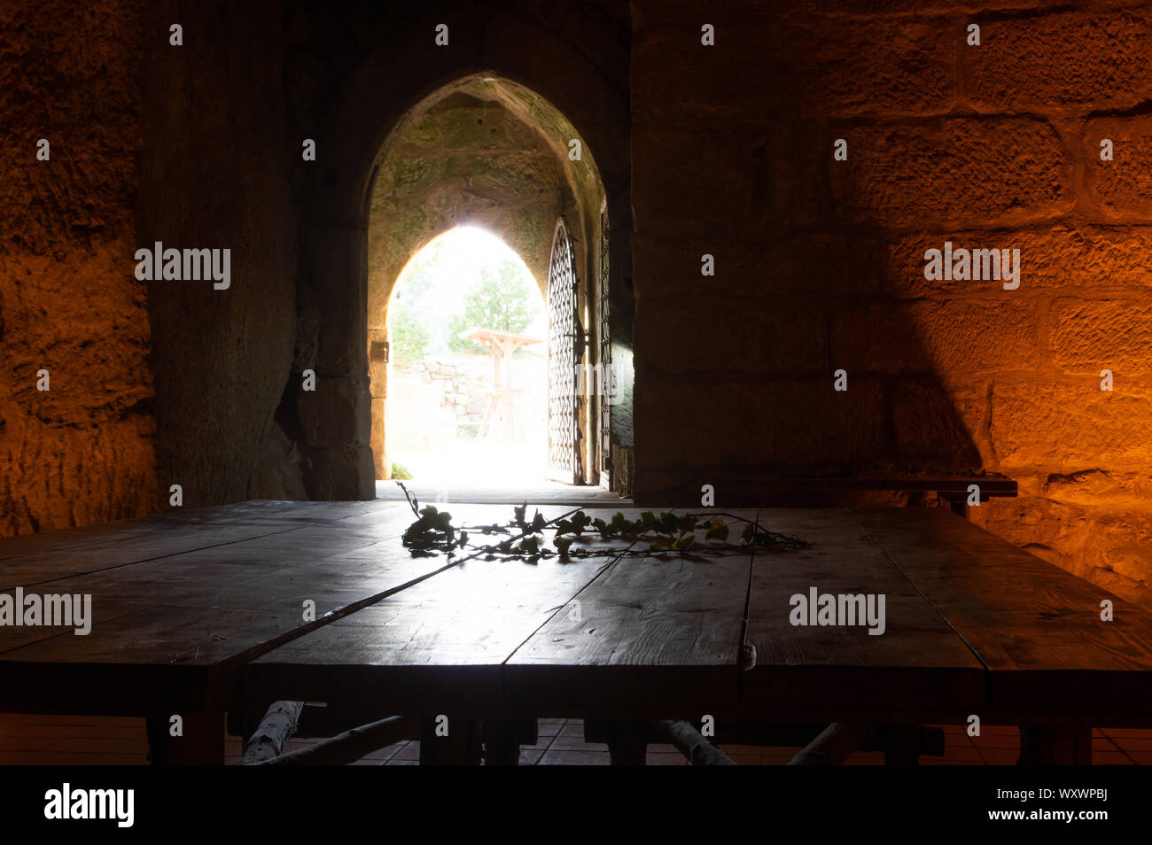 Holztisch in dunkle Kammer mit Licht von außen kommend Stockfoto