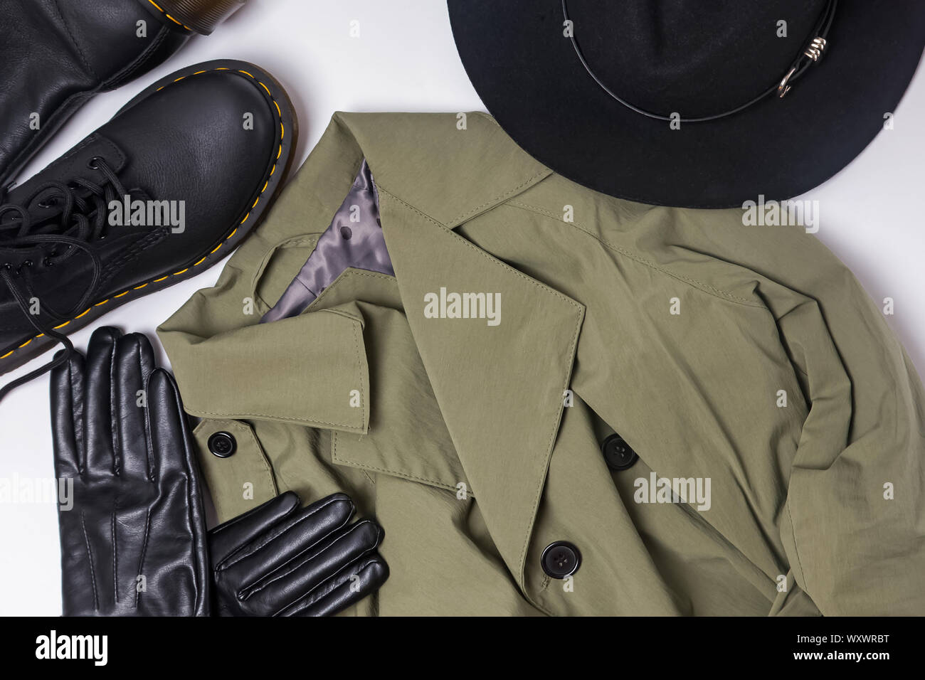 Herbst femininen Outfit auf den weißen Hintergrund. Trenchcoat, Hut, Handschuhe und Stiefel Top View Stockfoto