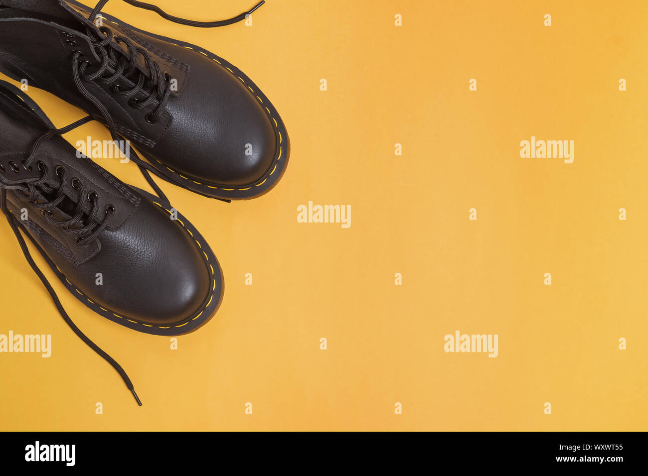Paar Unisex Classic Leder Stiefeletten auf gelbem Hintergrund, Ansicht von oben Stockfoto