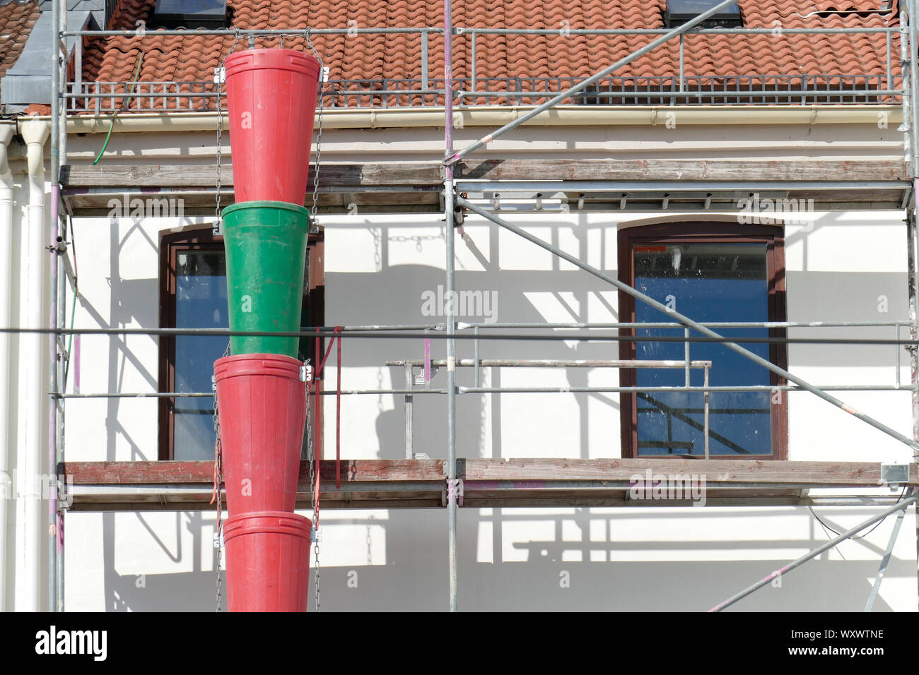 Gerüstbau in einem alten Gebäude mit bunten Plastikeimer Stockfoto