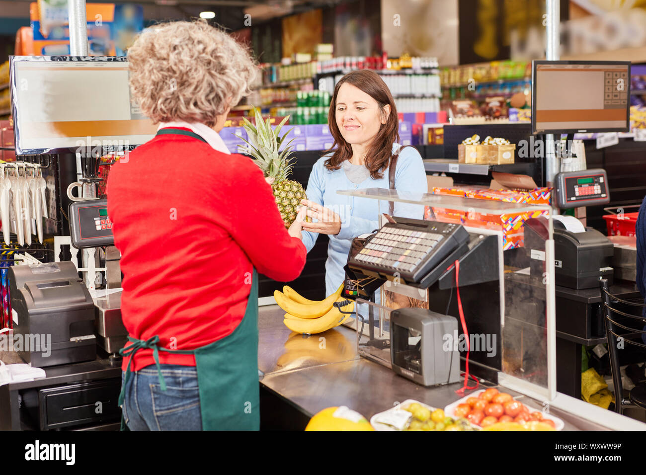 Kassierer und Kunden mit Obst im Supermarkt Kassierer beim Zahlen Stockfoto