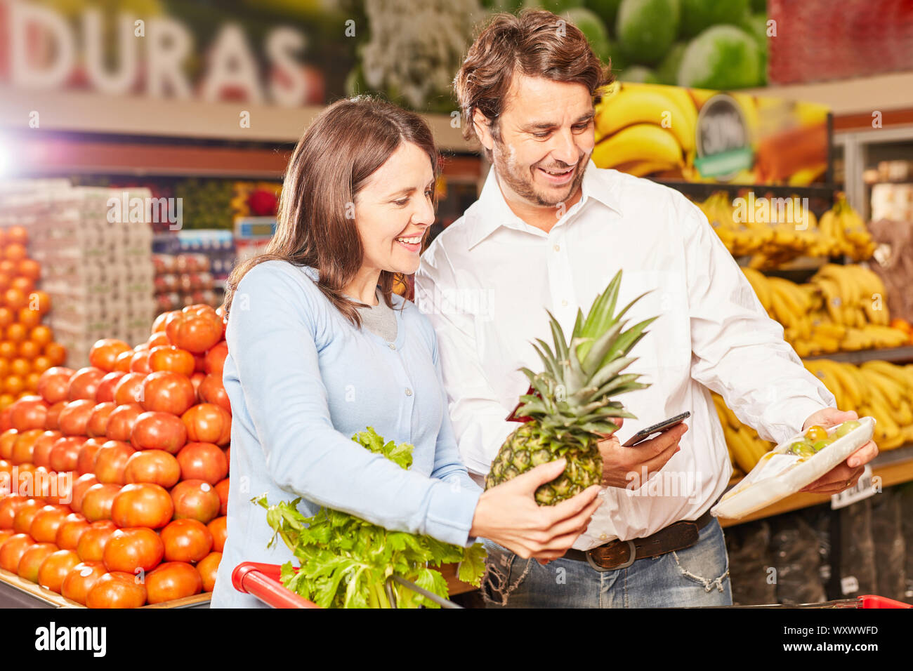 Junges Paar verwendet ein Smartphone App ein Pack von Obst zu scannen Stockfoto