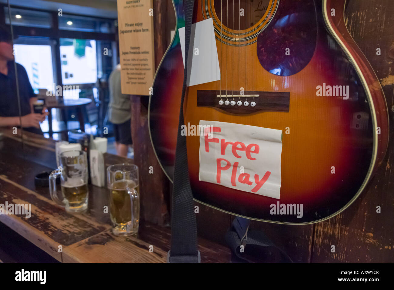 Tokio, Japan, 18.09.2019, Hinweis ad Menschen einladen, sich die Gitarre in der Bar zu verwenden. Stockfoto