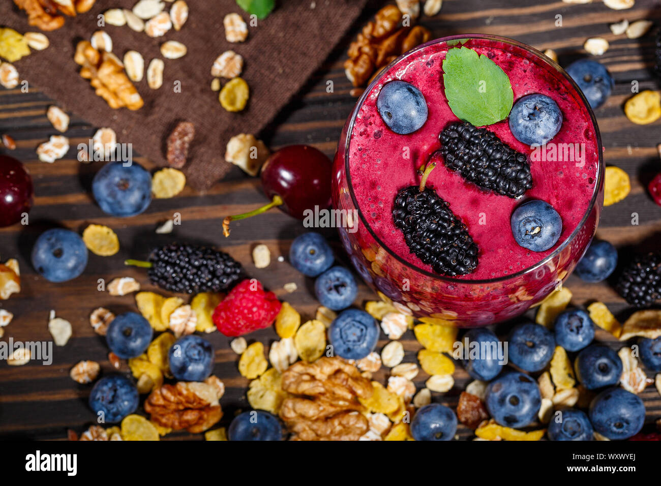 Glas Smoothies mit frischen Beeren und Müsli auf einem dunklen Hintergrund Stockfoto