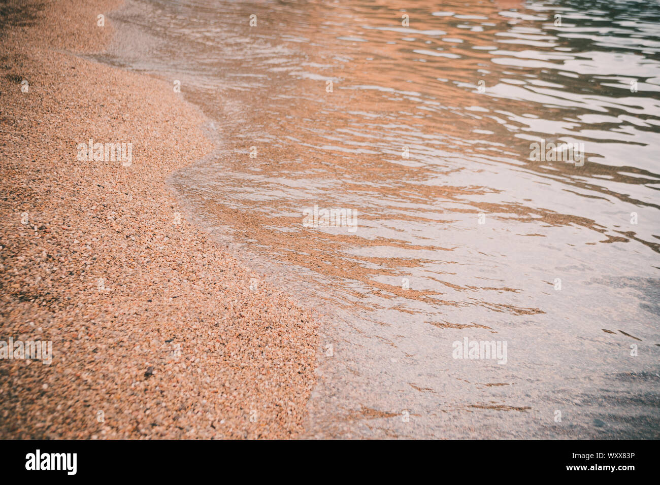 Meer Strand in den Tropen und den sanften Wellen des blauen Ozean. Sommer düsteren Tag und Sandstrand mit Steinen Hintergrund. Das Konzept der Sommerferien Stockfoto