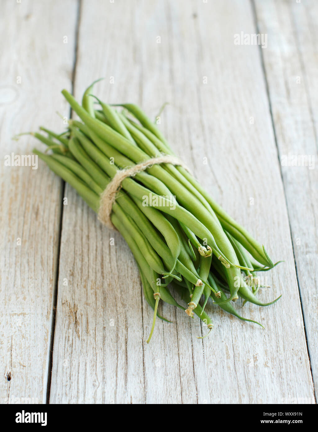 Frische grüne Bohnen auf einem hölzernen Hintergrund Stockfoto