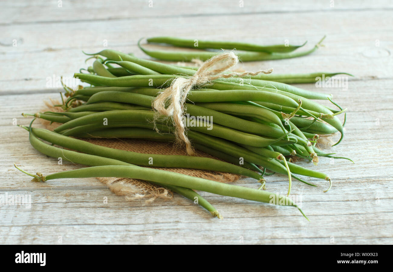 Frische grüne Bohnen auf einem hölzernen Hintergrund Stockfoto