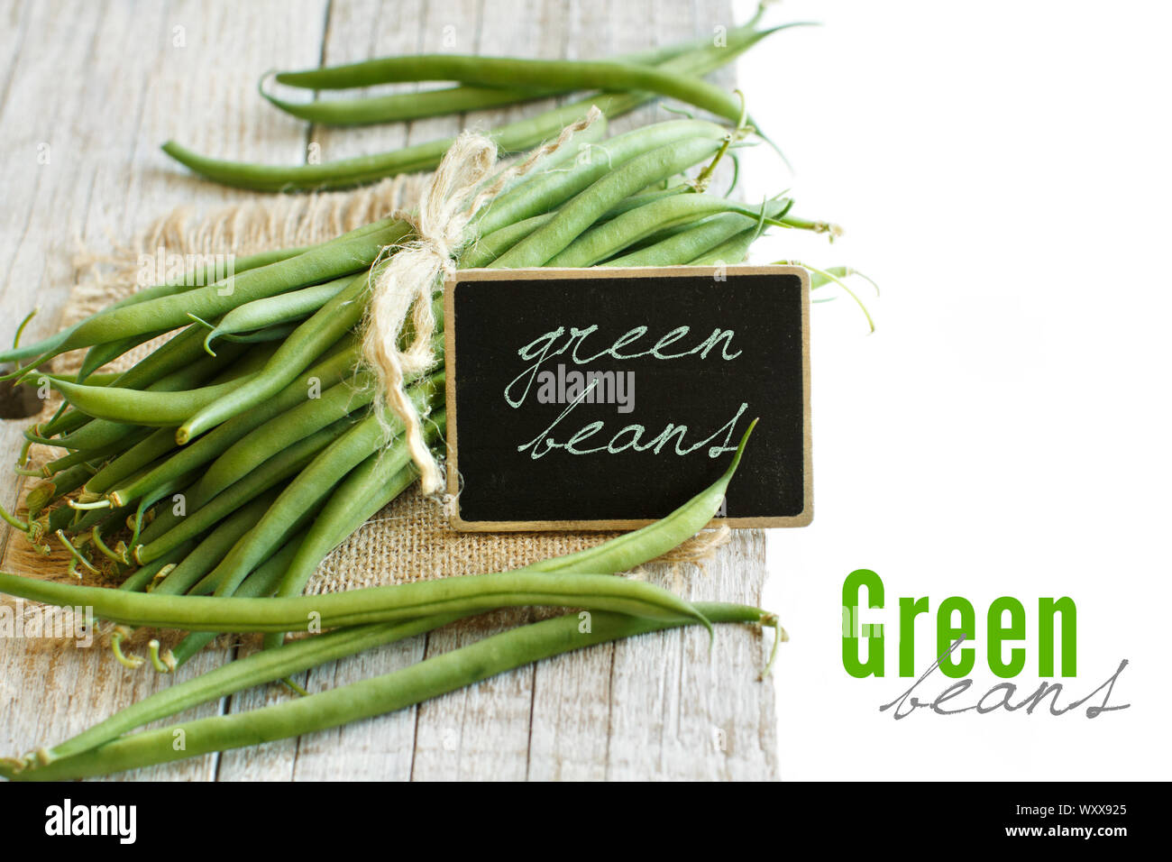 Frische grüne Bohnen auf einem hölzernen Hintergrund Stockfoto